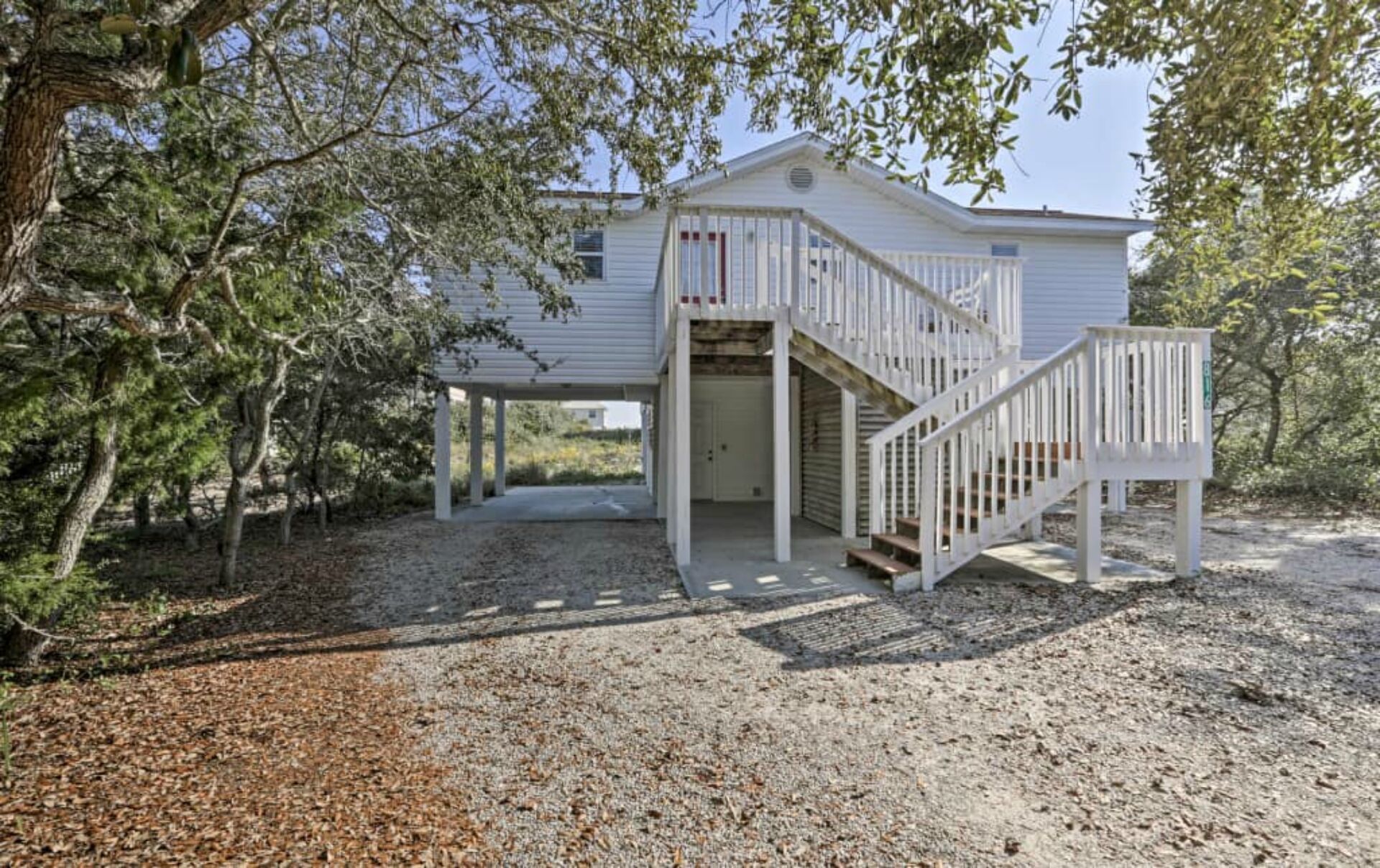 A single-story house with a covered porch and a staircase leading to a door.