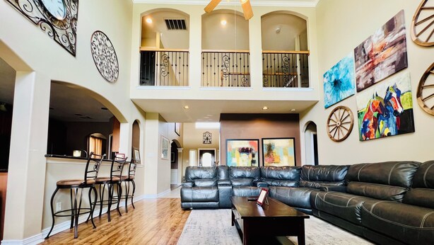 A spacious living room with a leather sofa, a coffee table, and a dining area with chairs.