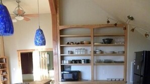 Una cocina con armarios de madera, un lavamanos, un microondas y un refrigerador.