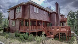 Une maison en bois à deux étages, dotée d’un balcon et d’une cheminée.