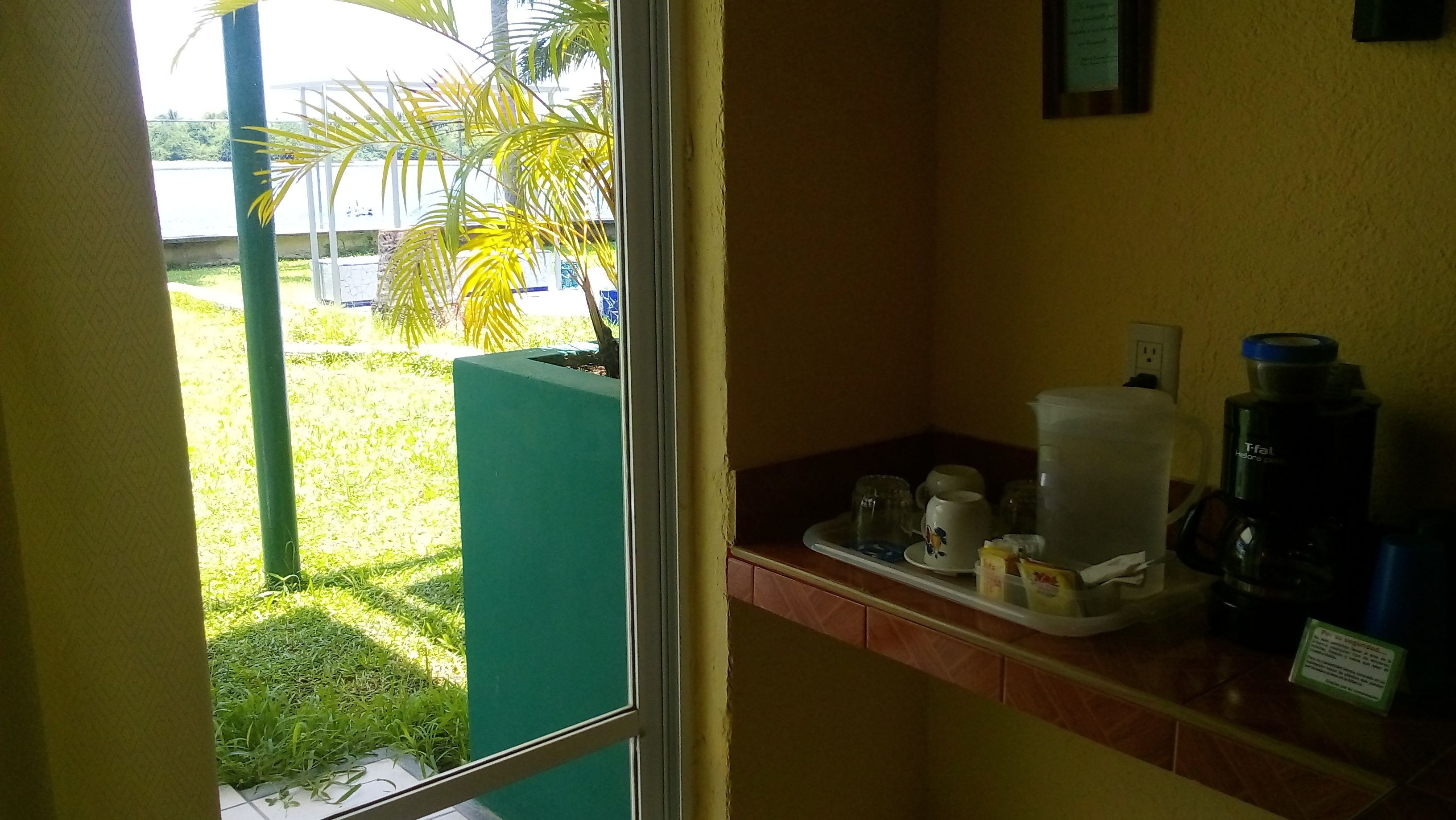 A small kitchenette with a coffee maker, a water dispenser, and a trash bin.