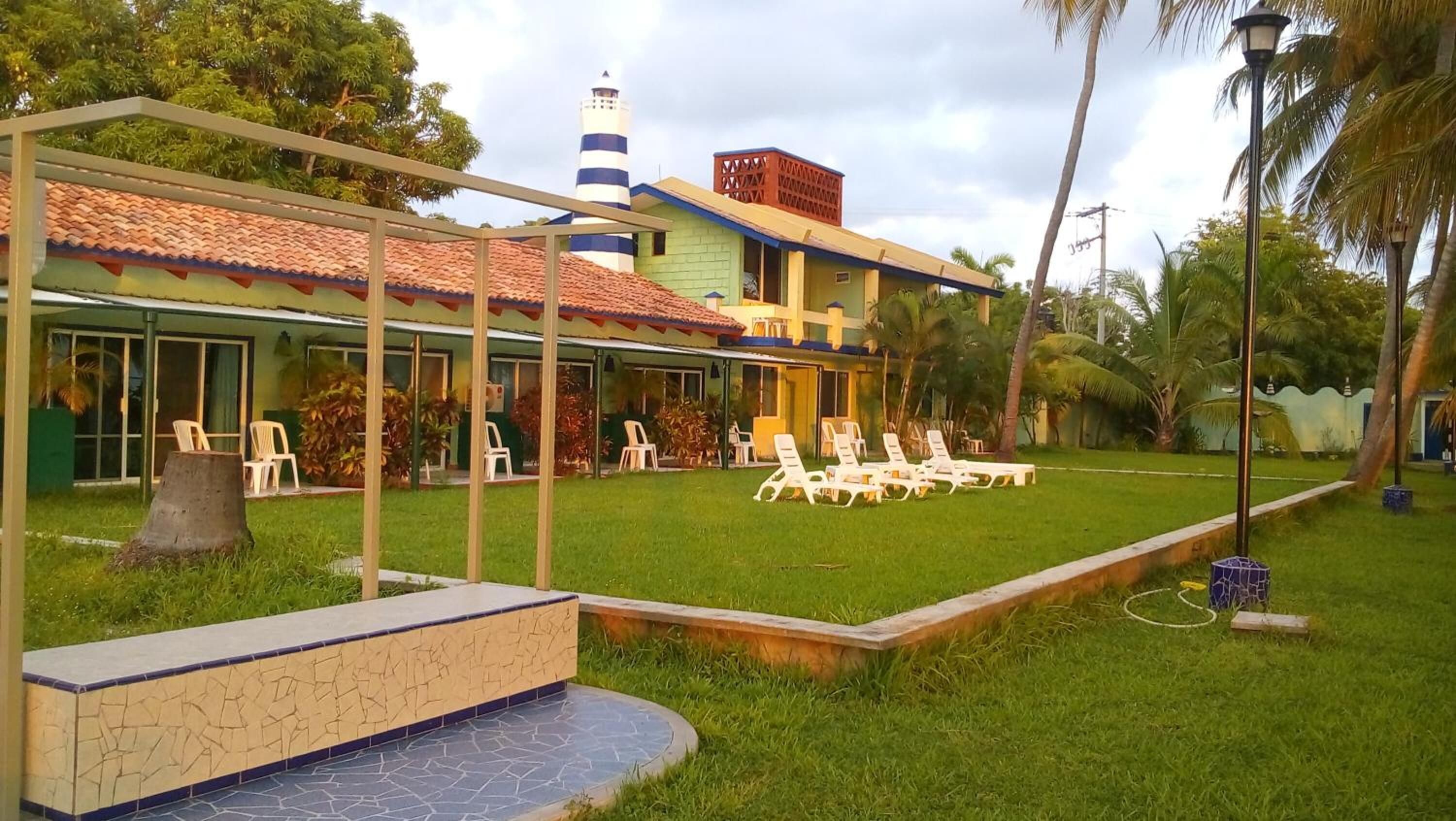 A hotel with a covered patio area, outdoor seating, and a small pool.