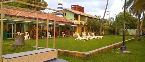 A hotel with a covered patio area, outdoor seating, and a small pool.
