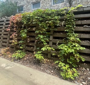 A stone building with a wooden fence partially covered by ivy. - Highest Rated, Lowest Rates in Snow Blaze: 2/2, A/C, Pool, Hot Tub, Gym, Firepit (Park City)