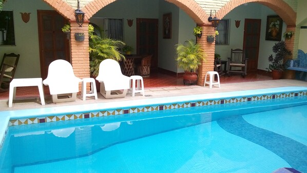 حمّام سباحة خارجي، مظلات على حمّام السباحة، مقاعد للتشمس