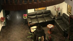 A multi-level living area with a wooden staircase, leather sofas, and a decorative fountain. - Hostal Santa Apolonia (Cajamarca)