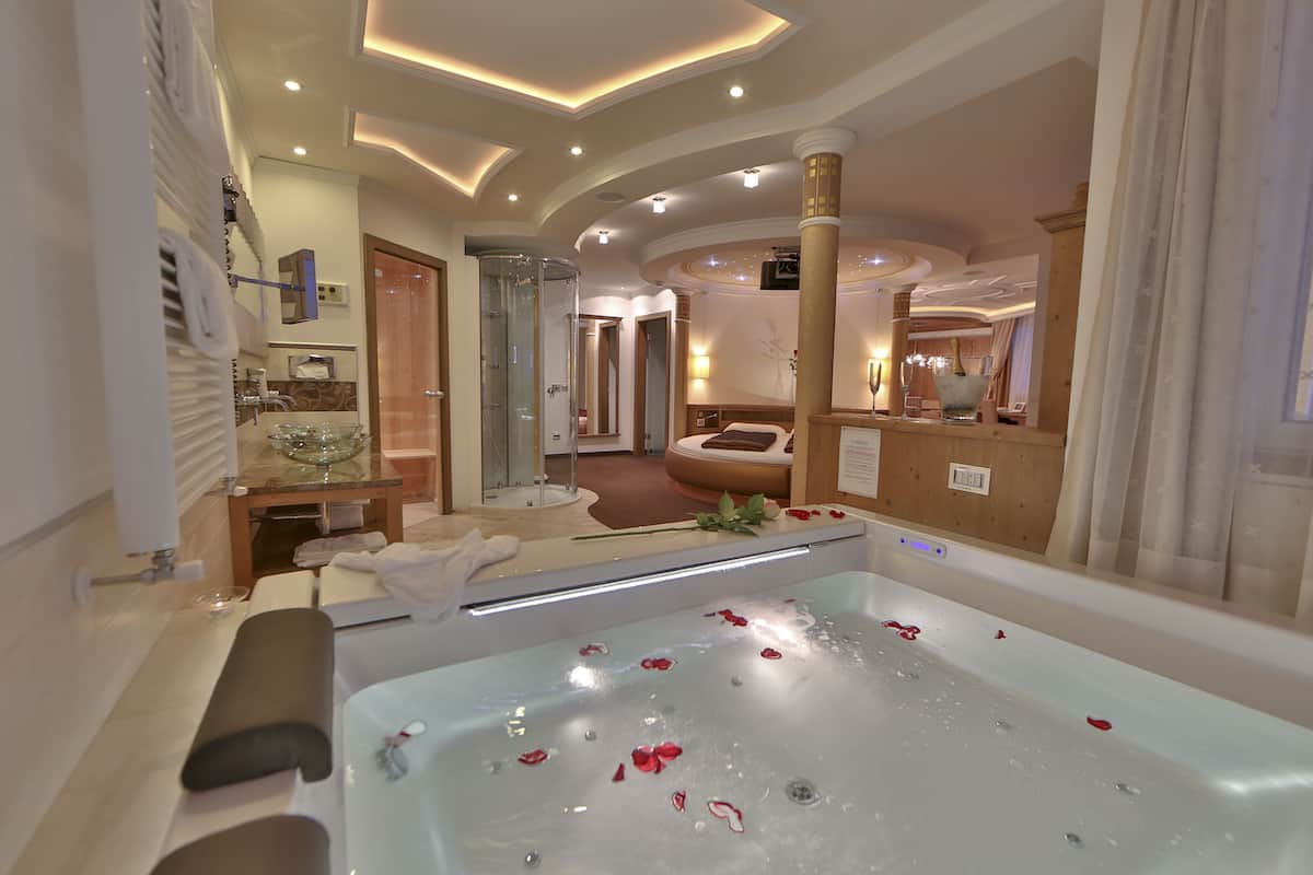 Ein modernes Badezimmer mit einer großen Badewanne, einer Duschkabine aus Glas und einem Waschtisch mit Spiegel.