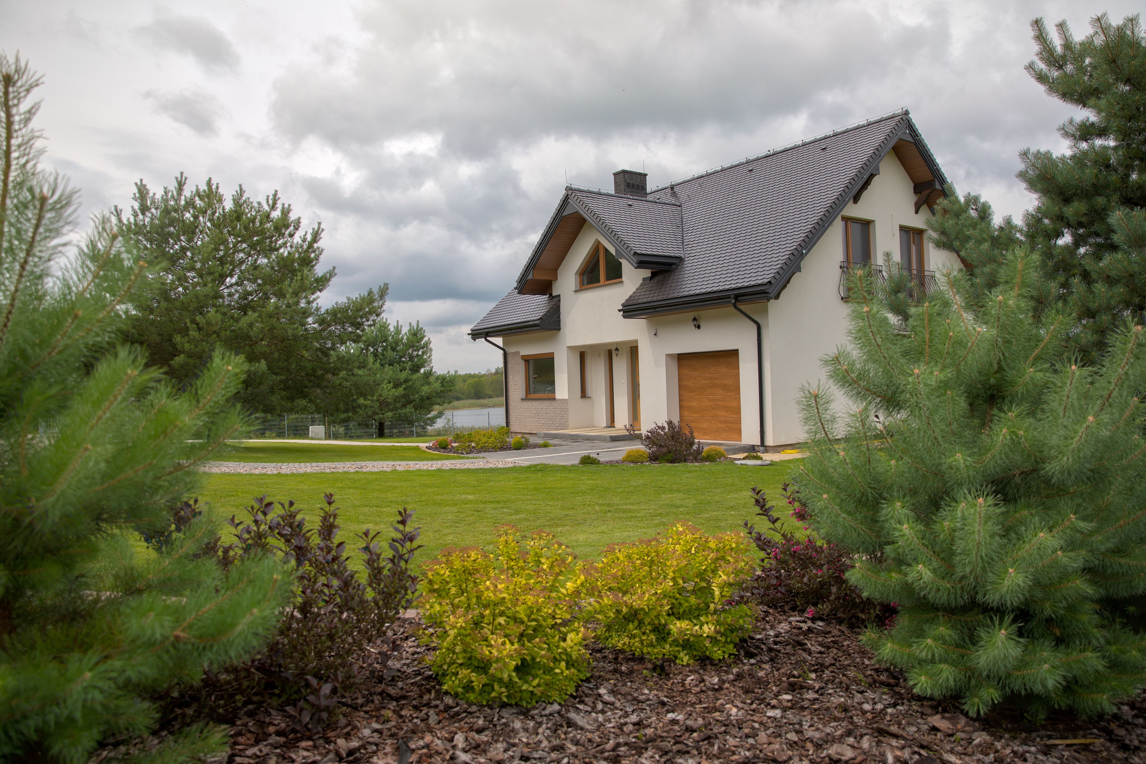 A two-story house with a sloped roof, a front porch, and a garage.