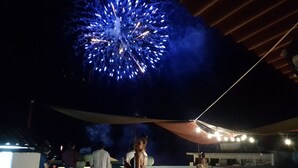 A rooftop terrace with a view of fireworks in the night sky. - Hostel Vallarta - Adults only (Puerto Vallarta)