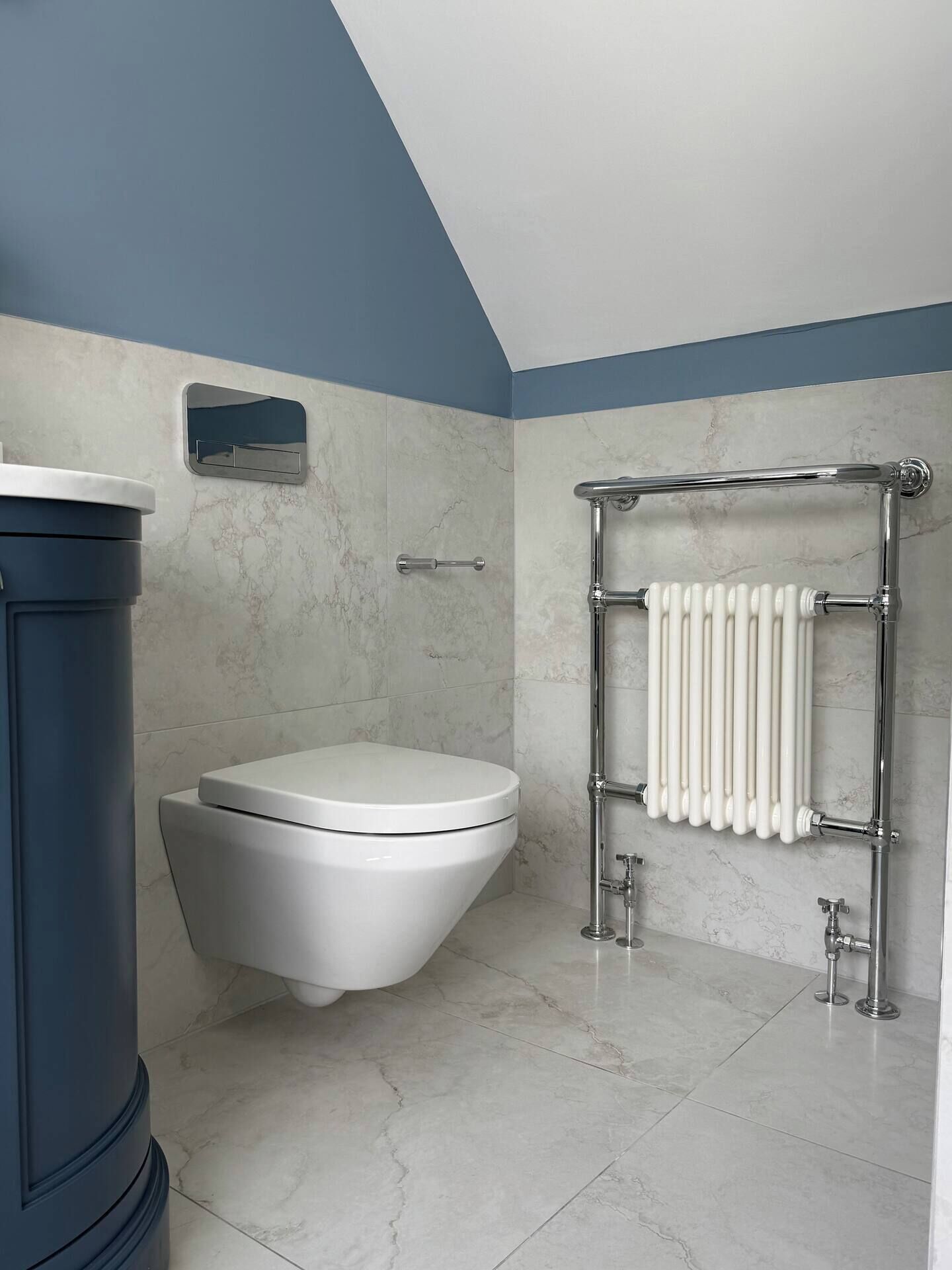 Une salle de bain avec des toilettes, un radiateur et un plafond bleu.