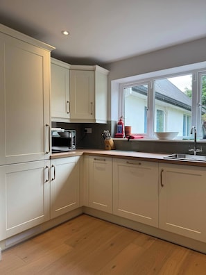 A kitchen with white cabinets, a window, and a sink.