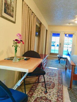Enjoy a meal for two at the dining table, with a view of the outside through the large window.