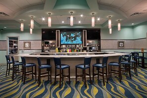 A bar area with a counter, bar stools, and a large screen displaying an underwater scene. - Pet-Friendly 5BR Retreat: Private Pool, Sleeps 11 - 8931 (Davenport)