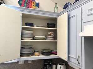 Kitchen area features a spacious cabinet with multiple shelves, perfect for storing dishes and kitchen essentials.