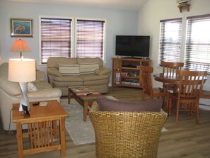 Relax in this inviting living space with a comfortable sofa, TV, and dining area.