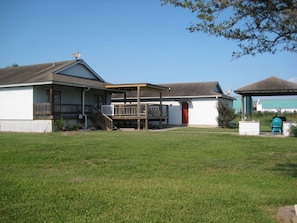 Relax in a shaded outdoor space with a covered seating area attached to this single-story house.