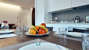 Een eettafel gedekt met borden, glazen en een schaal fruit.