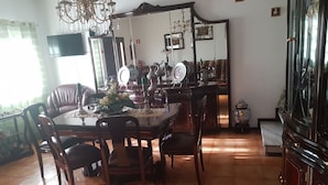A dining area with a wooden table, chairs, a chandelier, and a large mirror. - AL Santa Marta de Penaguião (Santa Marta de Penaguião)