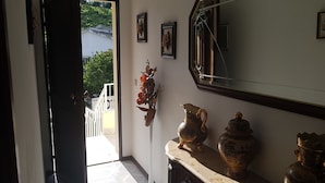 A hallway with a door leading outside, a mirror, and a marble console with decorative vases. - AL Santa Marta de Penaguião (Santa Marta de Penaguião)