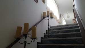A staircase with a handrail, a chandelier, and three framed pictures on the wall. - AL Santa Marta de Penaguião (Santa Marta de Penaguião)