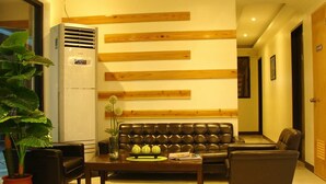 A modern living room with a leather sofa, a coffee table, and a potted plant. - Airport Poddotel (Pasay)