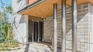 A modern building entrance with a covered area, glass doors, and a stone facade. - HOTEL -sui- HARUYOSHI (Fukuoka)