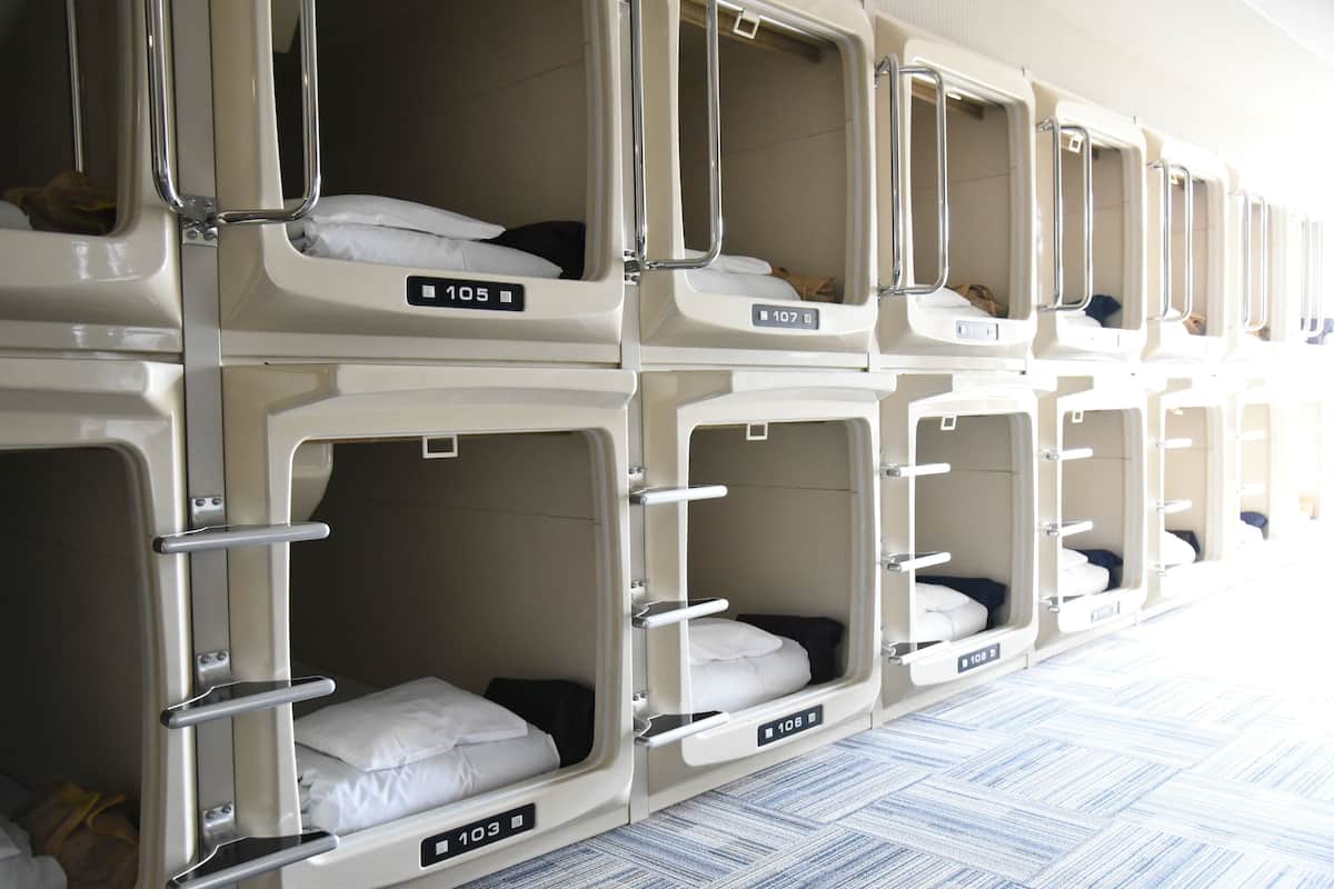 Reihe von Etagenbetten in einem Hotelzimmer, jedes Bett mit einer Nummer versehen.
