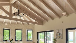 Una sala de estar amplia con un sofá seccional grande, una mesa de centro y un comedor con mesa y sillas.