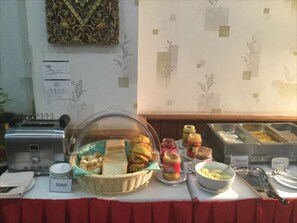 A buffet setup with a variety of food items including toast, bread, and condiments. - Crystal Palace Hotel (Yangon)