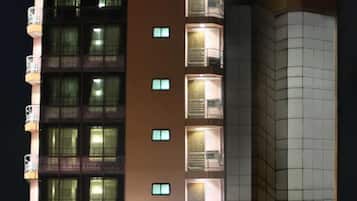 A hotel named Crystal Palace Hotel with a modern facade, multiple balconies, and a well-lit entrance.