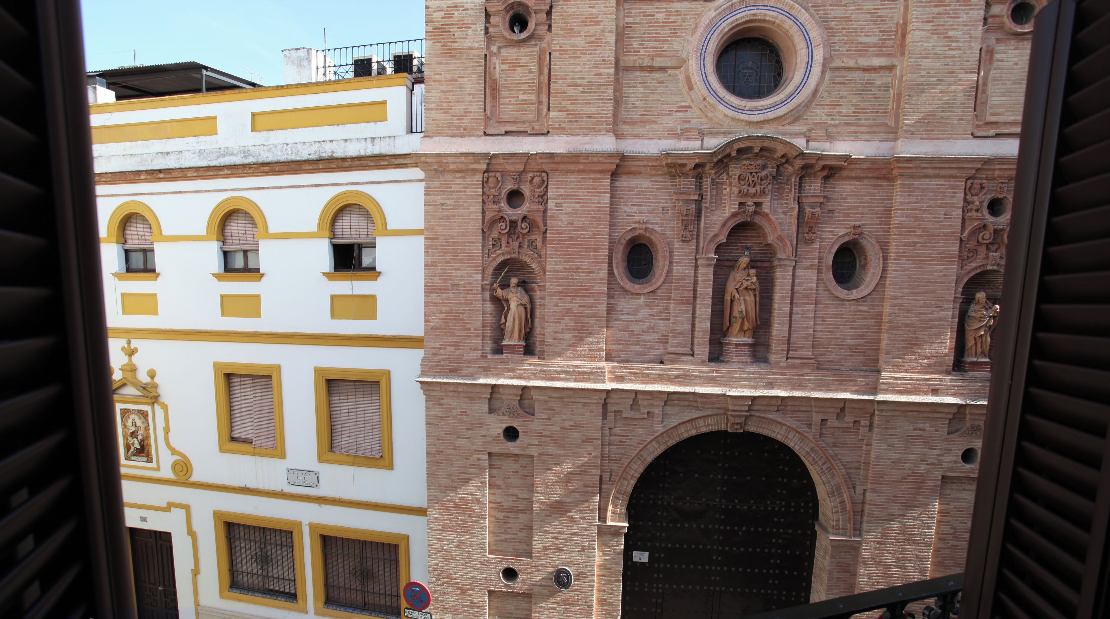 A view of a building with a large arched entrance and detailed brickwork.
