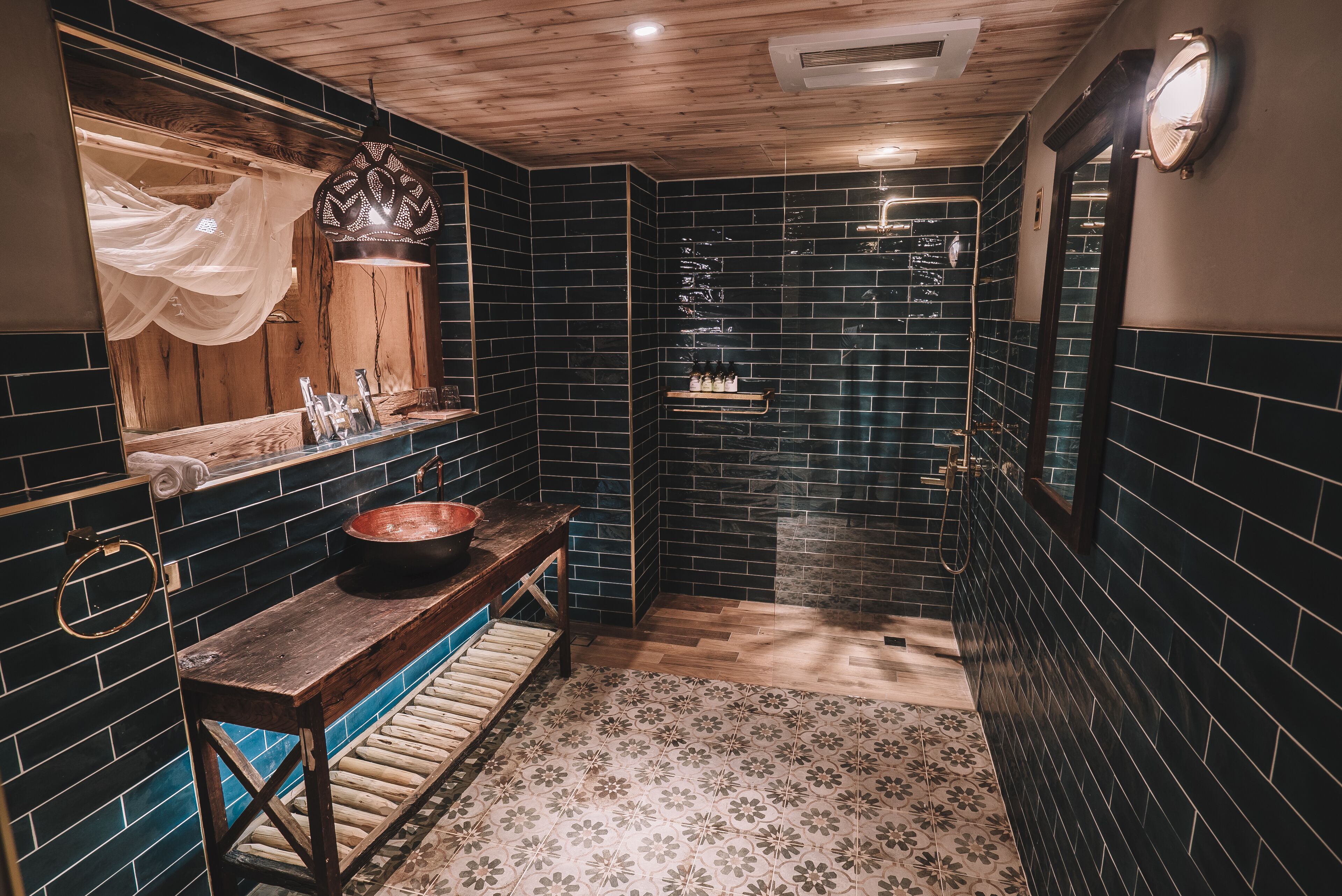 A bathroom with a wooden bench, a sink, and a mirror.