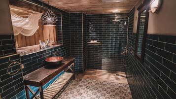 A bathroom with a wooden bench, a sink, and a mirror.