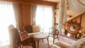 Une pièce chaleureuse avec un canapé, des fauteuils, une table ronde et un tapis à motifs.