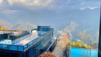 A modern building with a glass exterior and a pool.