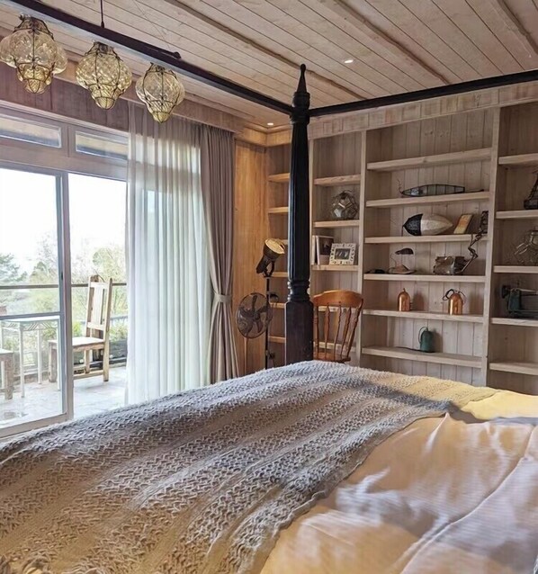 Un dormitorio con una cama grande, techo de madera y estantería empotrada.