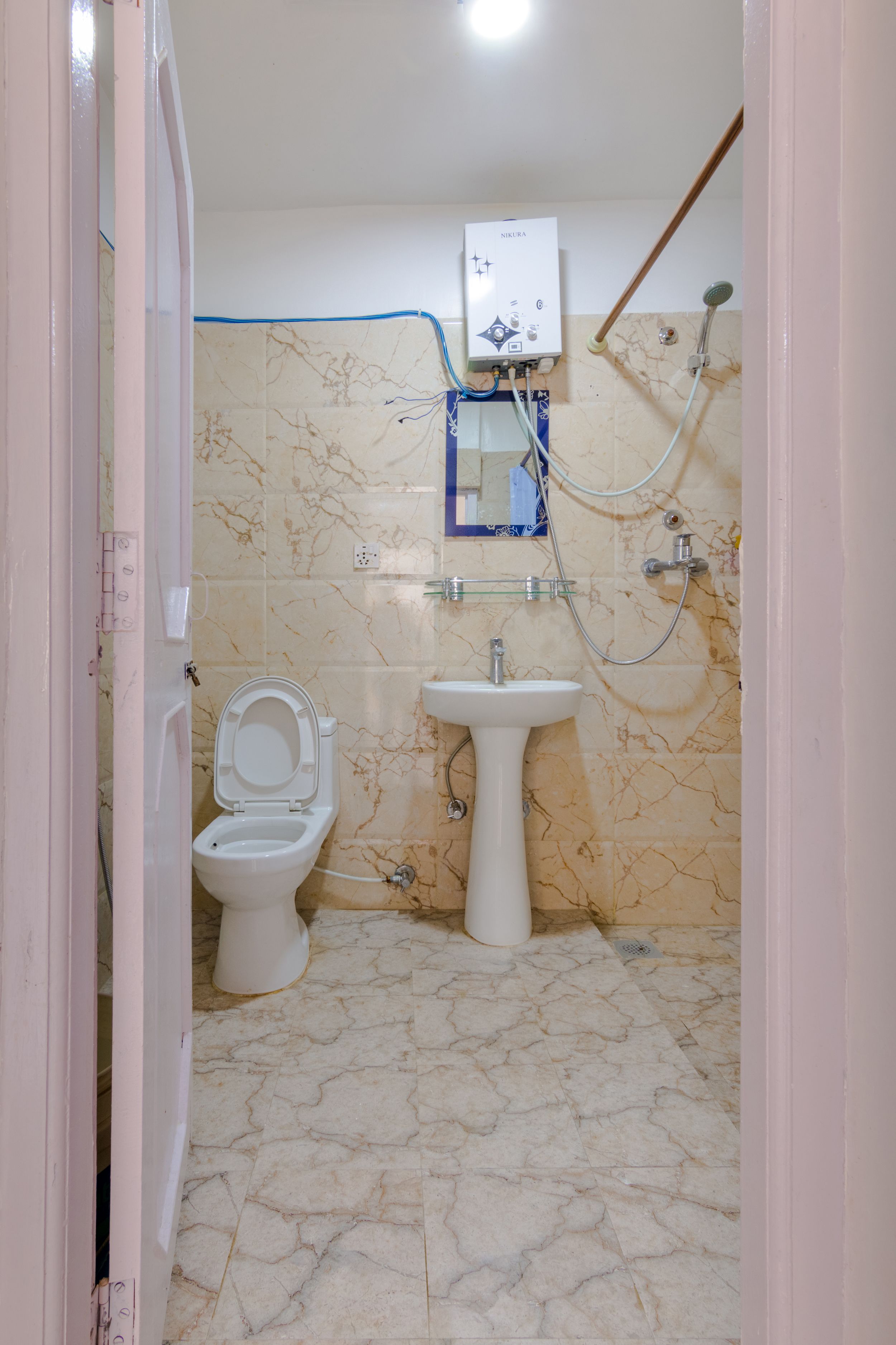 A bathroom with a toilet, sink, and shower.