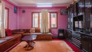 A room with a wooden bench, a small table, a cabinet, and a window with curtains. - Lemon Tree Apartment and Homestay (Tohka)