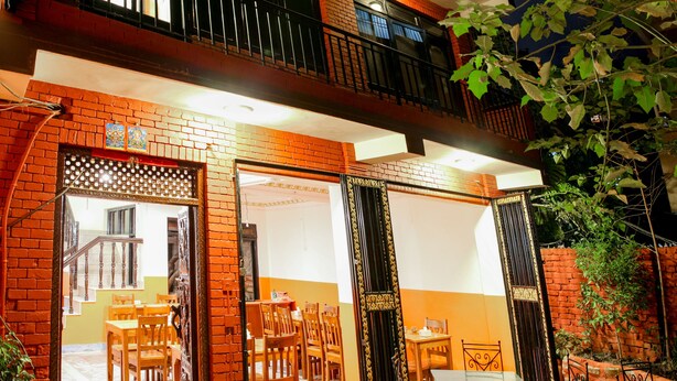 A two-story building with a brick facade, outdoor seating area, and a balcony. - Kathmandu Regency Hotel (Kathmandu)
