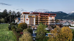 Un hôtel à plusieurs étages doté de balcons, d’une piscine et offrant une vue sur les montagnes.
