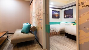 Hotellihuone, jossa on sänky, sohva, seinällä oleva kartta ja ikkuna, josta avautuu näkymä kaupunkiin.