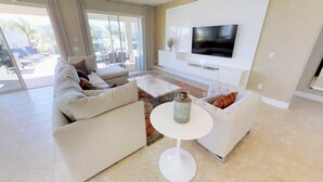 A modern living room with a sofa set, a coffee table, and a flat-screen TV mounted on the wall. - Aco246871 - The Encore Club Resort - 9 Bed 8.5 Baths Villa (Kissimmee)