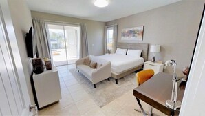A modern hotel room with a bed, a desk, a chair, a television, and a window with curtains. - Aco246871 - The Encore Club Resort - 9 Bed 8.5 Baths Villa (Kissimmee)