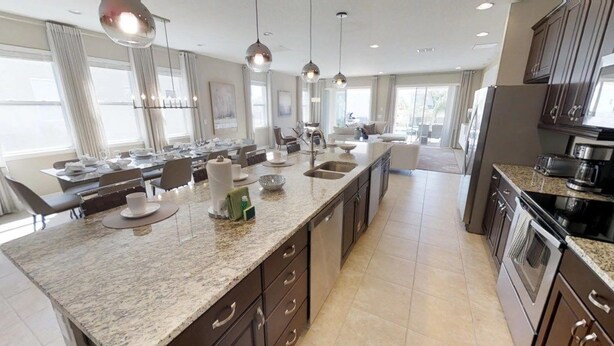 A spacious kitchen with a large island, modern appliances, and pendant lighting. - Aco246871 - The Encore Club Resort - 9 Bed 8.5 Baths Villa (Kissimmee)