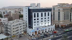A hotel with a modern facade, multiple floors, and a prominent entrance with arches. - Zaha Al Munawara Hotel (Madinah)