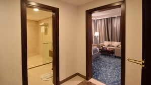 A hotel room with a shower, a sofa, and a coffee table. - Zaha Al Munawara Hotel (Madinah)
