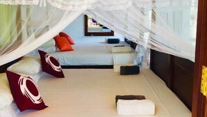 A bedroom with a canopy bed, a ceiling fan, and a view of the outside. - Villa White (Hikkaduwa)