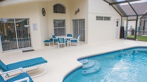 A covered outdoor swimming pool with lounge chairs and a table. - Ip60144 - Westridge - 4 Bed 3 Baths Villa (Davenport)