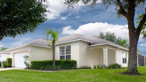A single-story house with a front garage, a well-maintained lawn, and a large tree in the foreground. - Ip60144 - Westridge - 4 Bed 3 Baths Villa (Davenport)