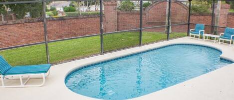 En säsongsöppen utomhuspool, parasoller och solstolar